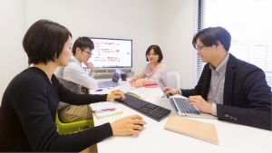 社員4人が和やかな雰囲気でミーテイングをしている様子